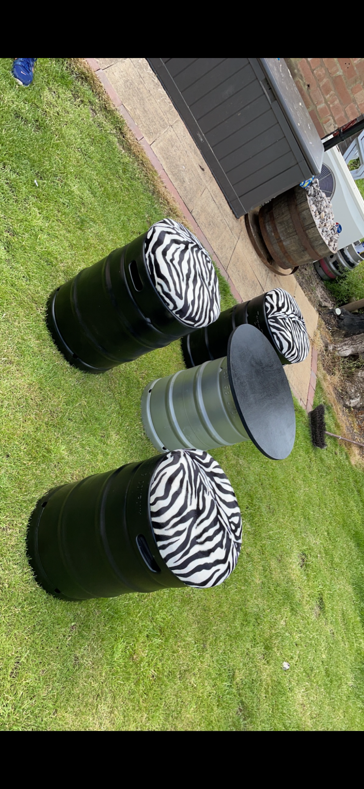 Black keg stools with zebra tops in garden